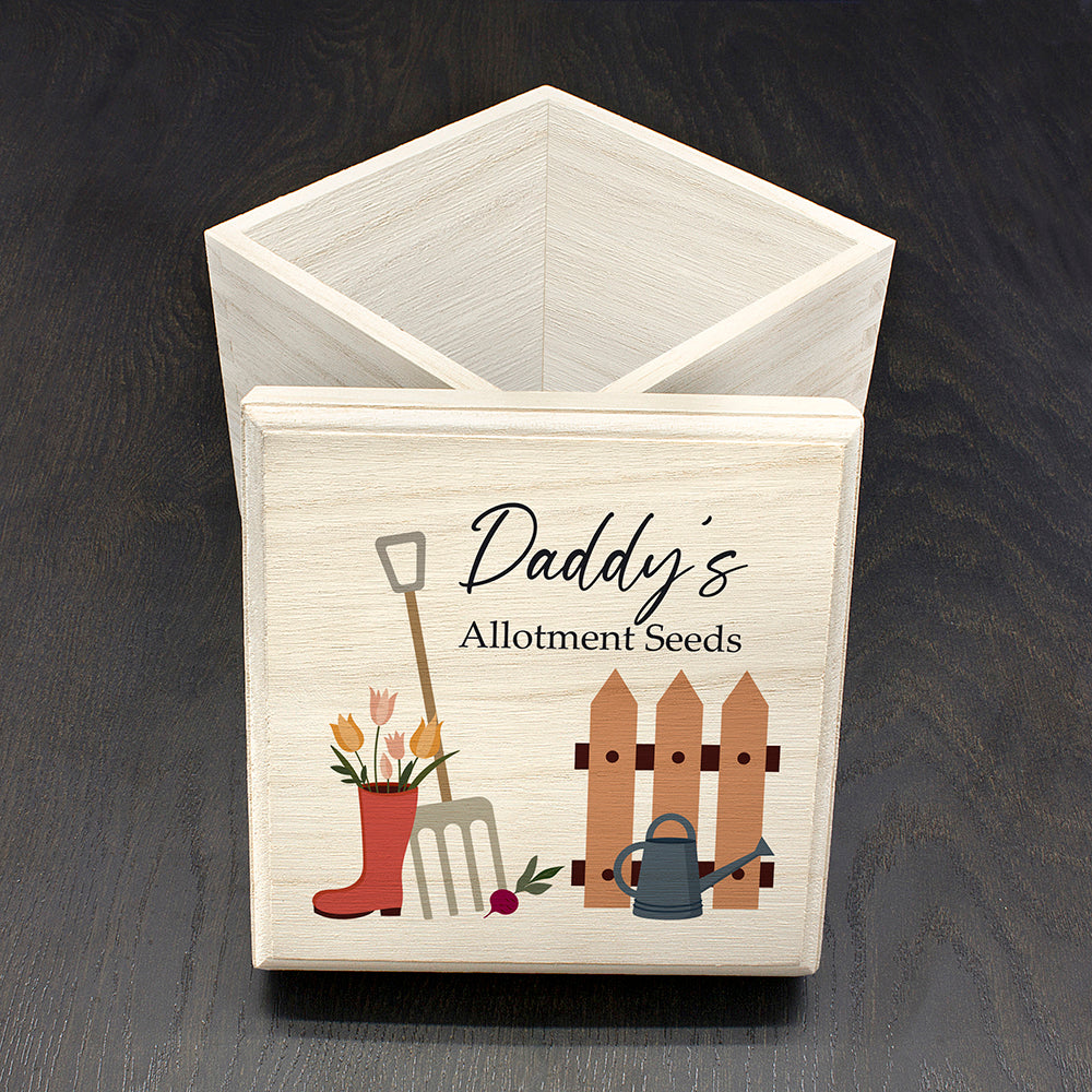Wooden box with gardening-themed design and 'Daddy's Allotment Seeds' text on a dark surface.