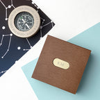 Brown box with 'KM' emblem on a white and blue geometric background