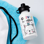 White water bottle with cat illustration and text on a blue towel