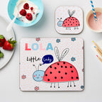 Two children's placemats with ladybug designs on a table with food.