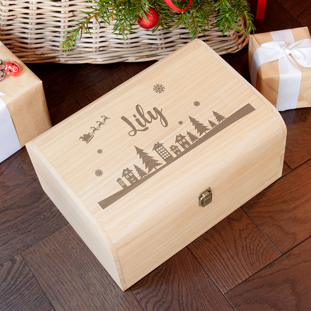 Wooden box with 'Lily' engraving on a wooden floor with Christmas decorations.