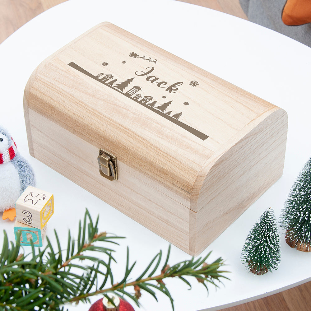 Wooden box with 'Jack' engraved on it, surrounded by Christmas decorations.