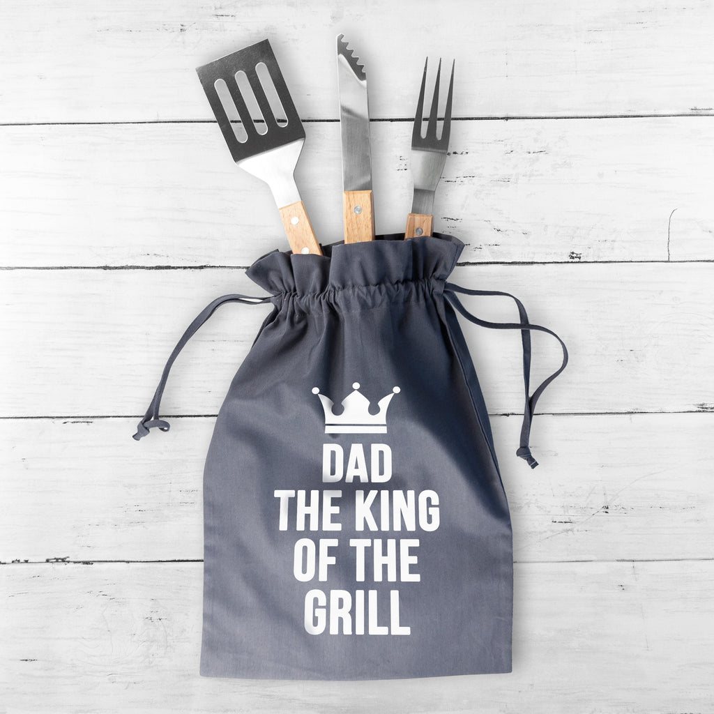 Gray drawstring bag with BBQ tools and 'Dad, The King of the Grill' text on a wooden surface