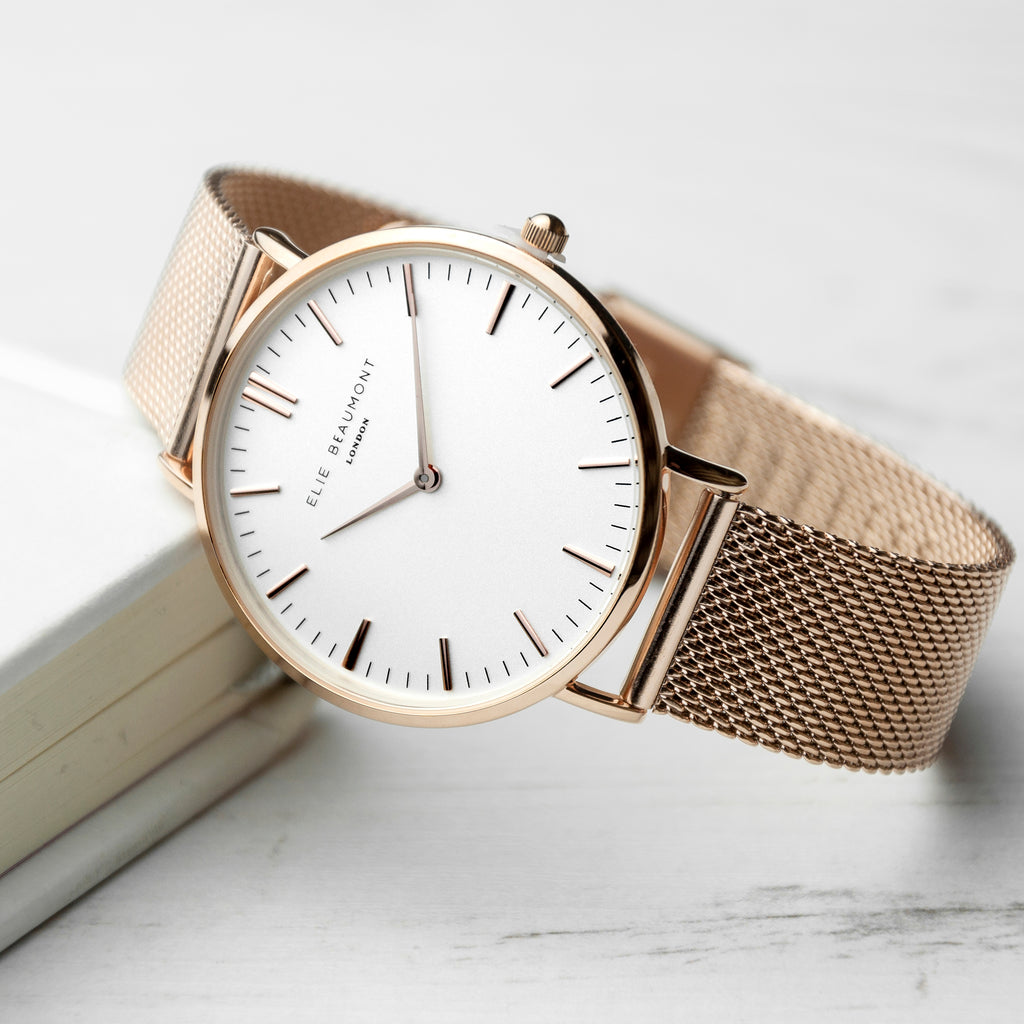 Wristwatch with beige mesh strap on a light background