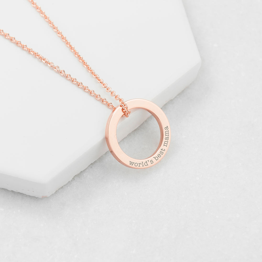 Rose gold necklace with 'world's best mom' pendant on a light gray background