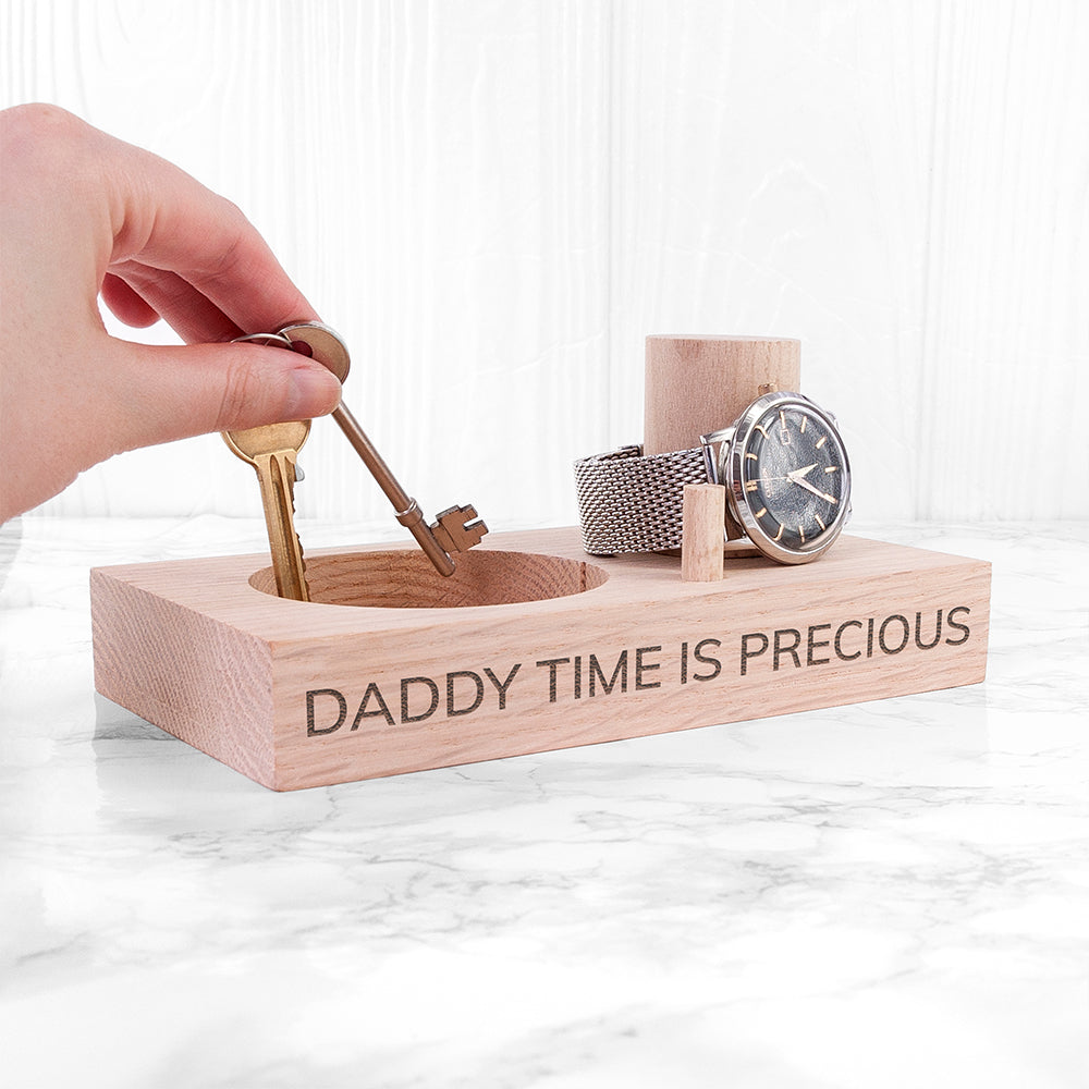 Wooden stand with 'Daddy Time is Precious' text holding a watch and small tools on a marble surface.