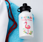 White water bottle with colorful flamingo design and text on a blue towel