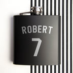 Black flask with 'ROBERT' and number '7' on a black and white striped background