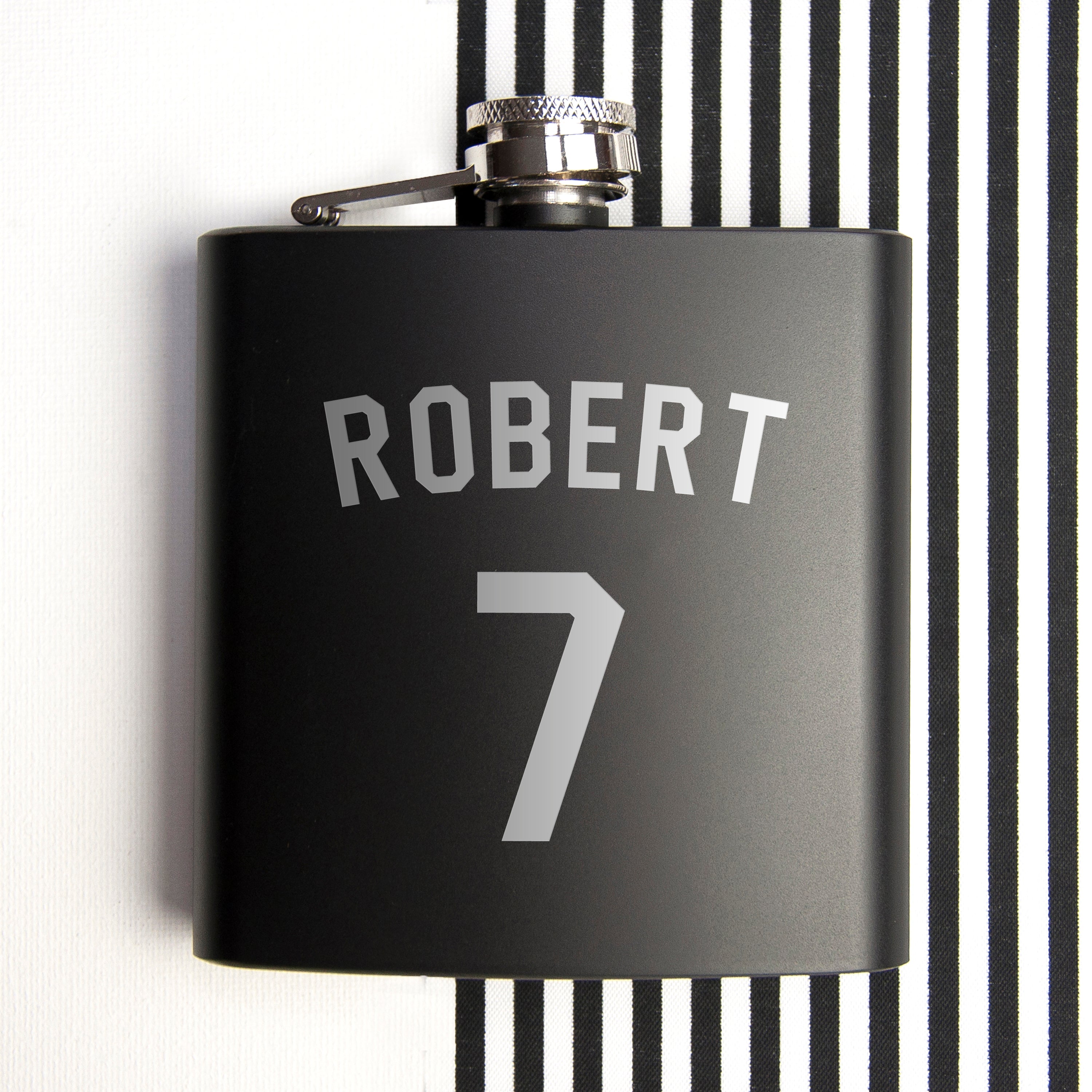 Black flask with 'ROBERT' and number '7' on a black and white striped background