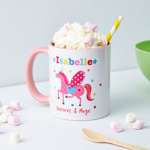 Mug with pink unicorn design and text 'Isabelle Unicorns & Magic' filled with hot chocolate and whipped cream.