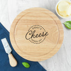 Wooden cheese board with 'Daddy's Cheese Hands Off' engraving on a white surface with a knife and cheese.