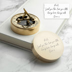 Gold compass and decorative box on a marble surface with a romantic message.