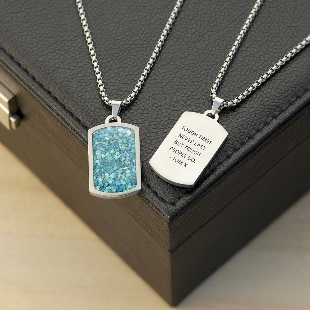 Two necklaces with pendants on a dark surface