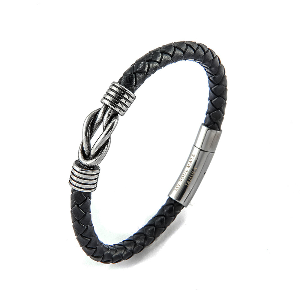 Black braided leather bracelet with silver metal accents on a white background