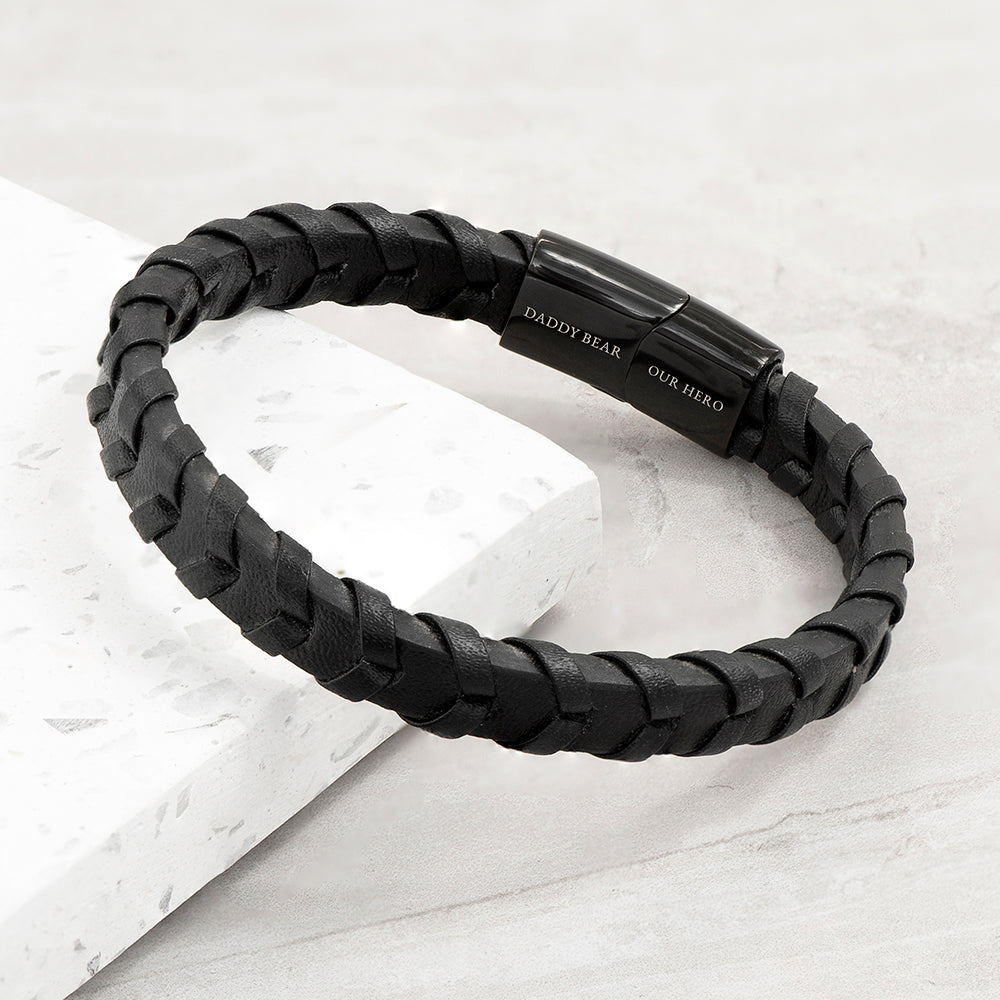 Black braided bracelet with a clasp on a light gray background