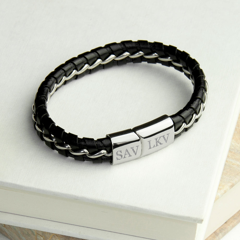 Black braided leather bracelet with silver tag on a white surface