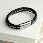 Black braided leather bracelet with silver tag on a white surface