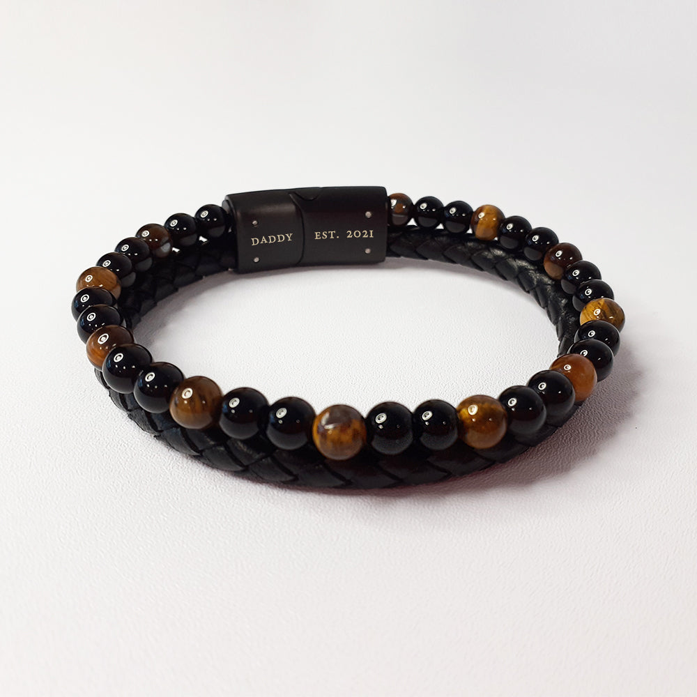 Black and brown beaded bracelet with a black clasp on a white background