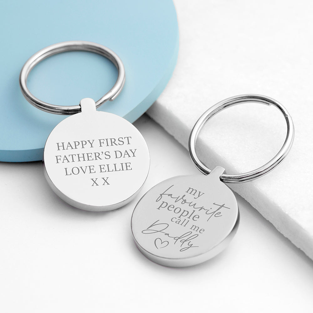 Two silver keychains with engraved messages on a light blue and white background