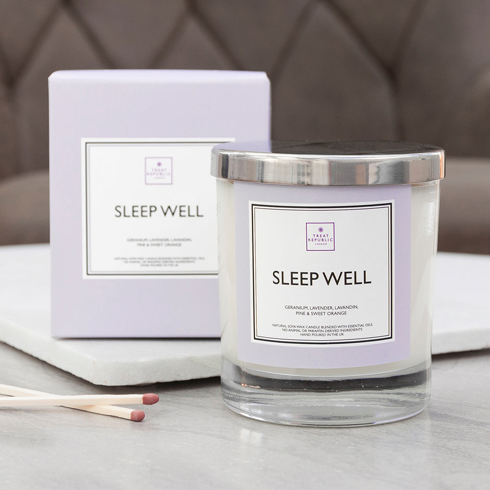 Sleep Well candle and packaging on a surface with a neutral background