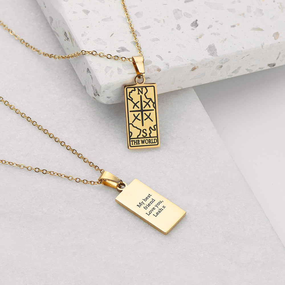 Gold pendant necklace with engraved text on a light background