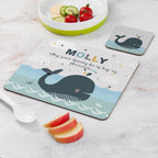Personalized placemat with whale design and message, placed on a marble surface with fruit and a bowl.
