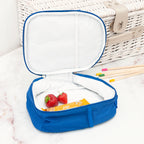 Blue insulated lunch bag with strawberries and snacks on a white surface