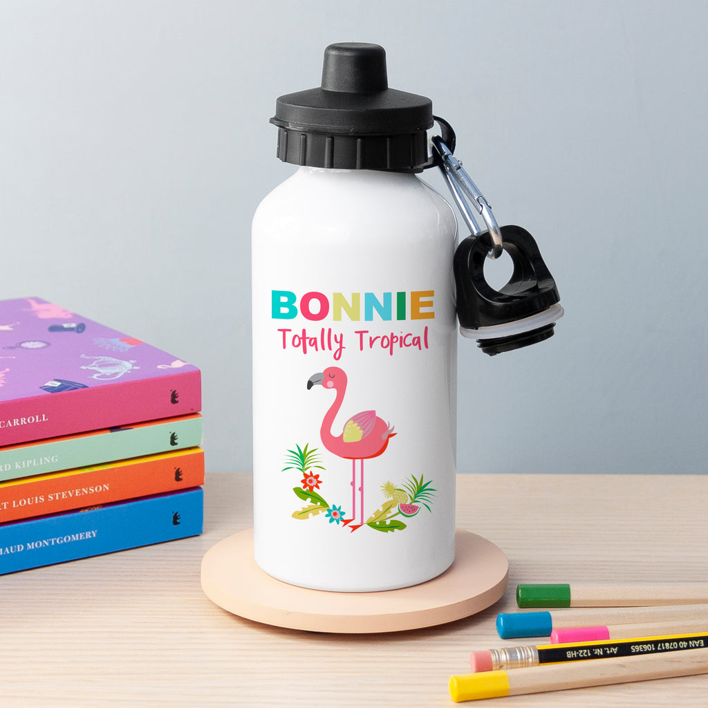 White water bottle with flamingo design and 'Bonnie Totally Tropical' text on a wooden stand with books and pencils in the background.