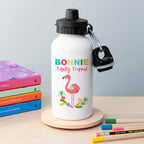 White water bottle with flamingo design and 'Bonnie Totally Tropical' text on a wooden stand with books and pencils in the background.